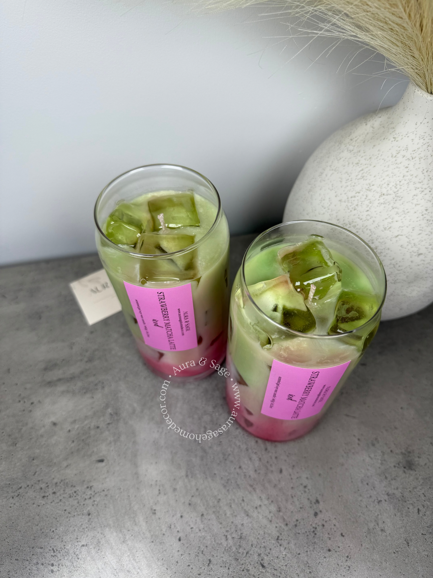 Strawberry matcha latte drink-inspired candle in glass container.