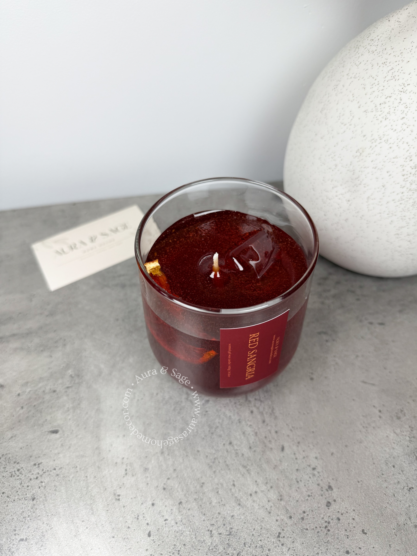 Red sangria drink-inspired candle in glass container.