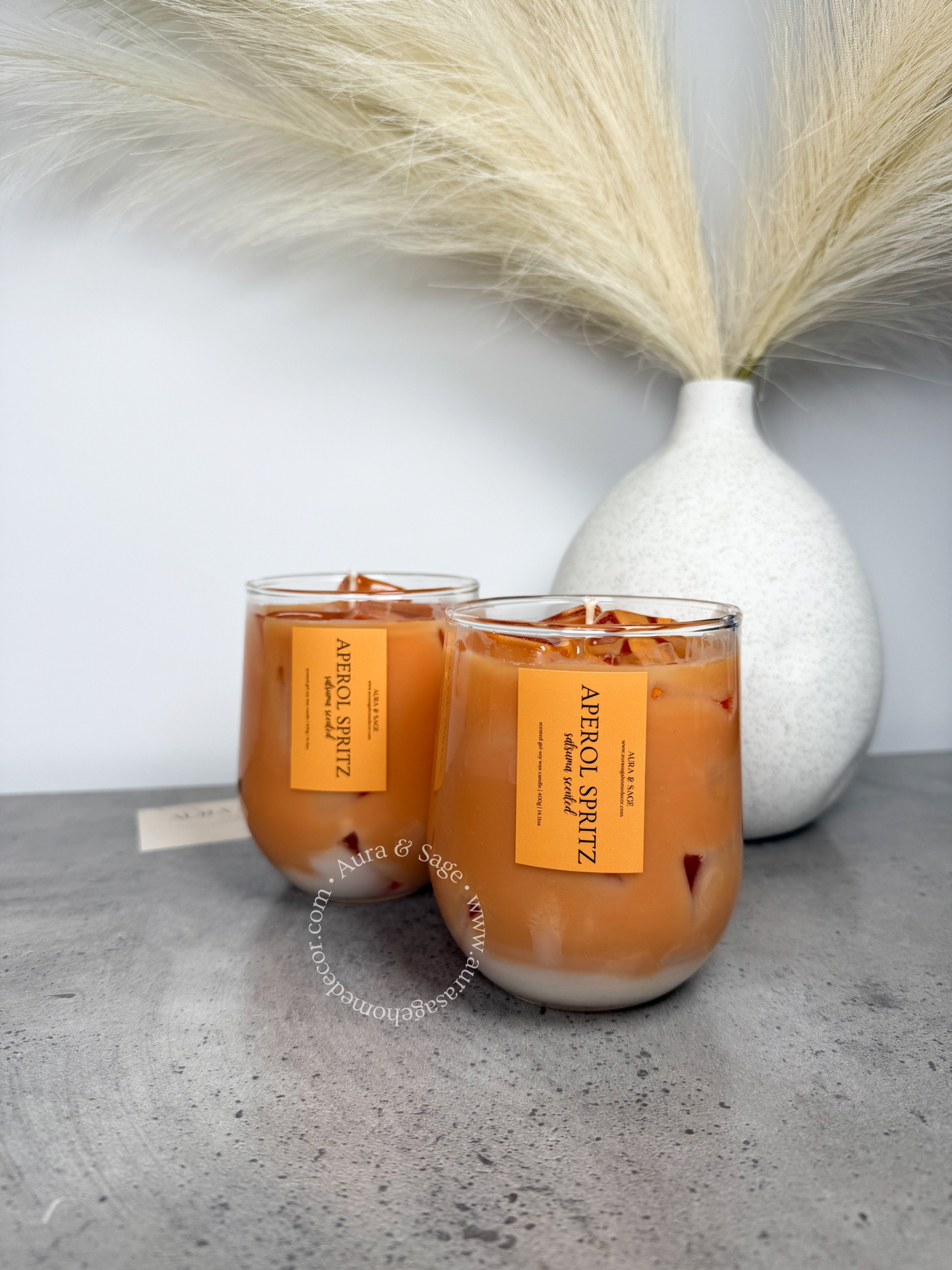 Aperol spritz drink-inspired candle in glass container.