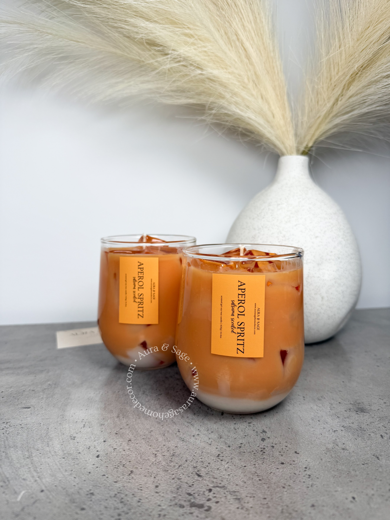 Aperol spritz drink-inspired candle in glass container.