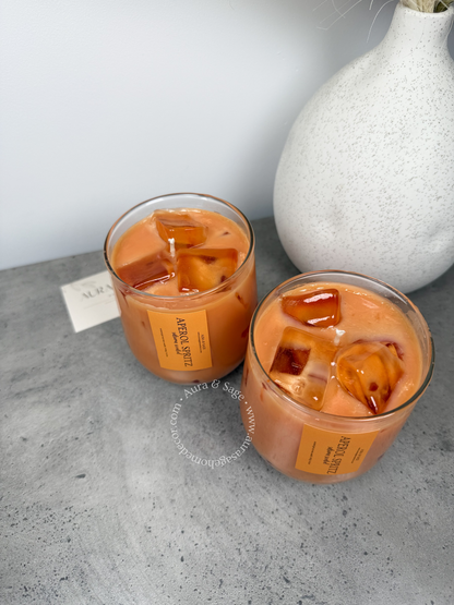 Aperol spritz drink-inspired candle in glass container.