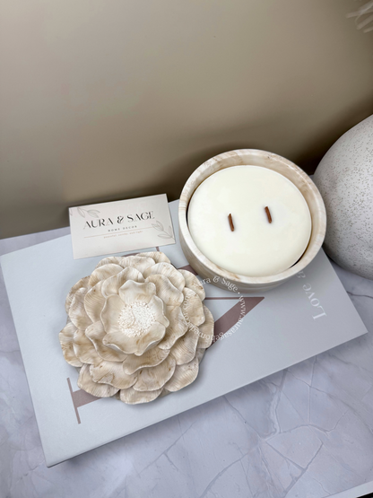 Candle in a decorative flower-shaped container.