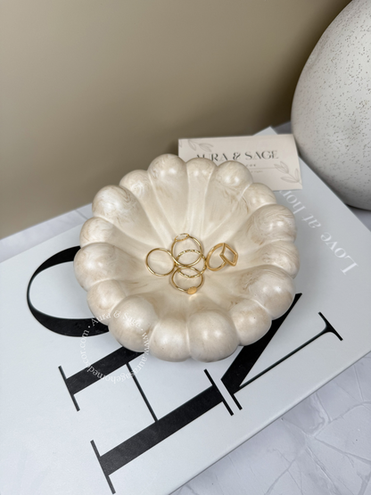 Pearl-like decorative bowl with gold rings.