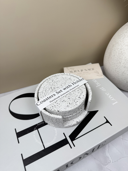 Set of speckled coasters with holder on a magazine