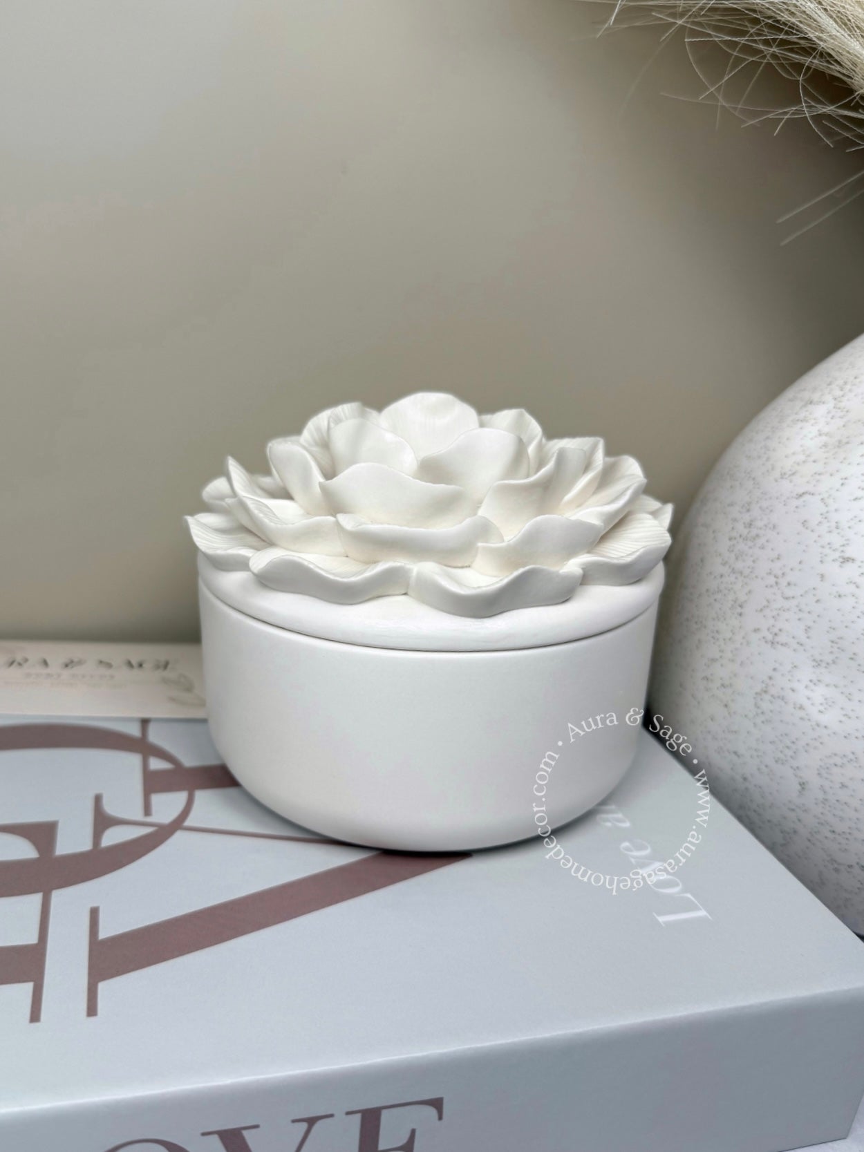 White ceramic flower-shaped container on a surface with a neutral background
