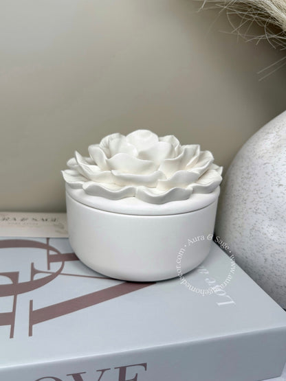 White ceramic flower-shaped container on a surface with a neutral background