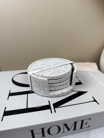 Set of silver grey granite stone coasters on a book