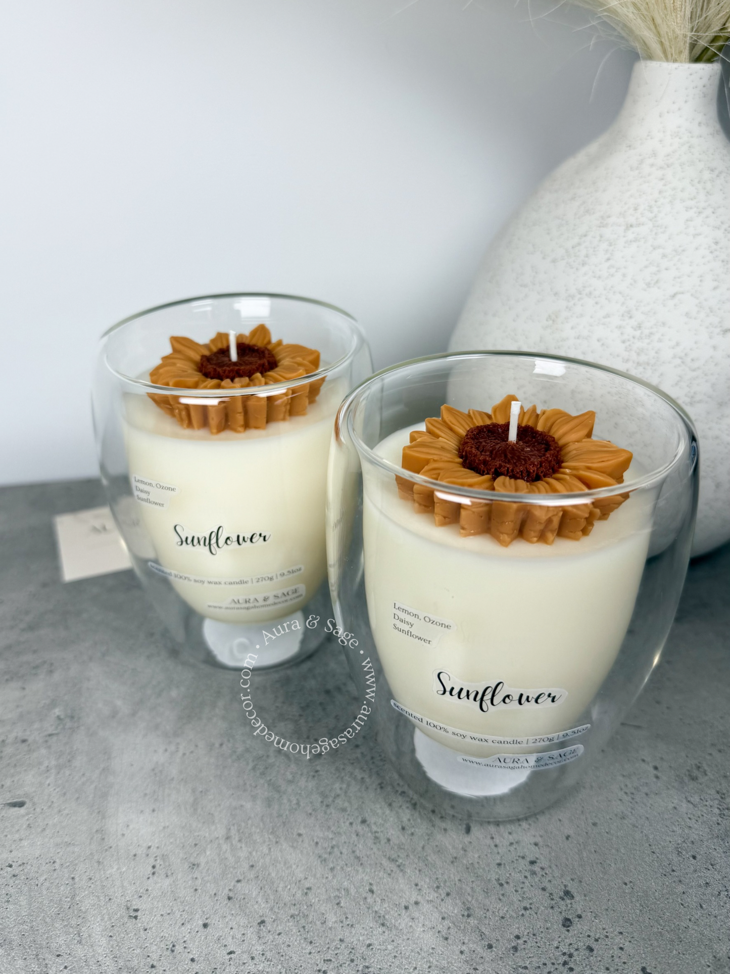 Sunflower decorated candle in glass container.